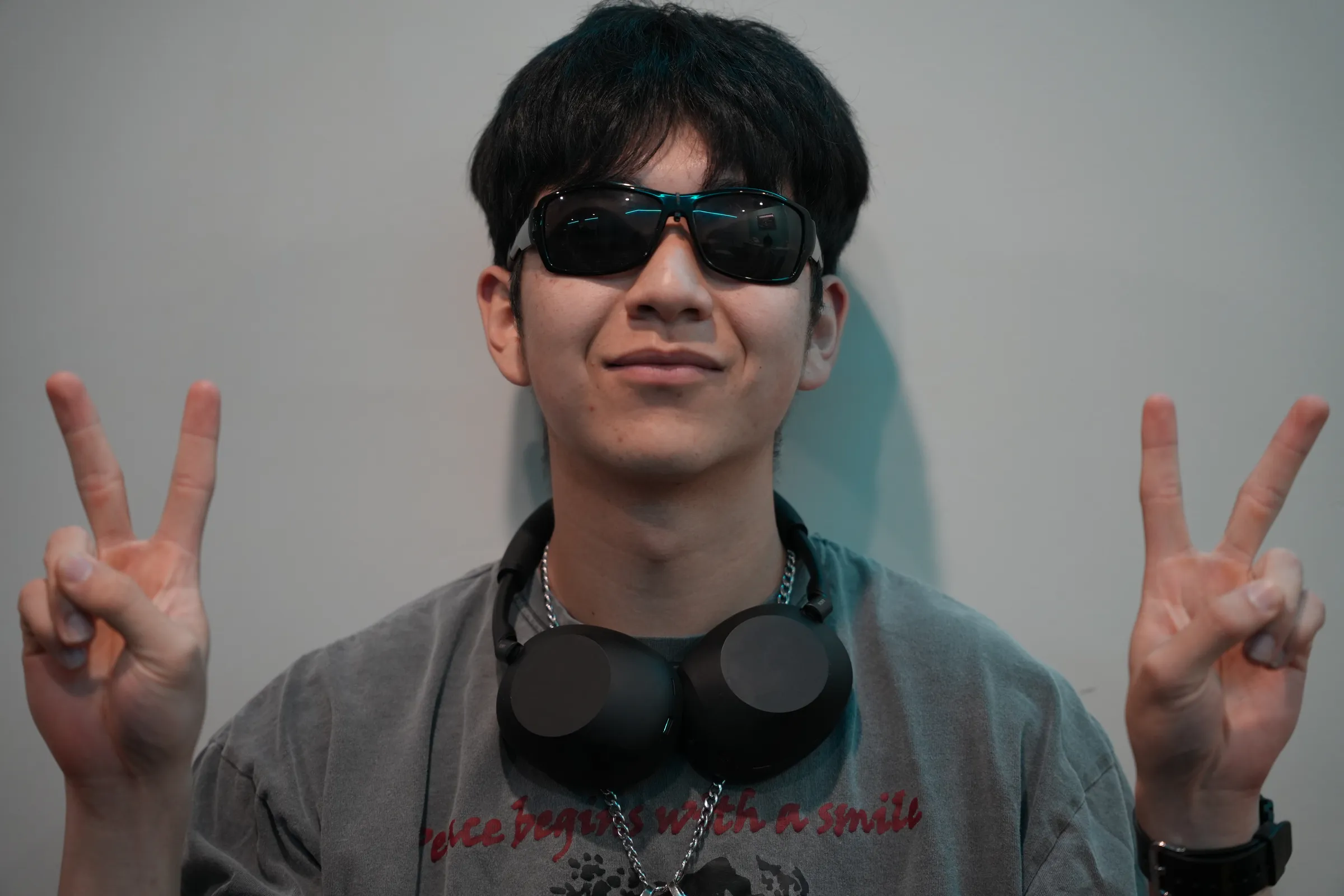 A member in sunglasses throwing peace signs at arcade night
